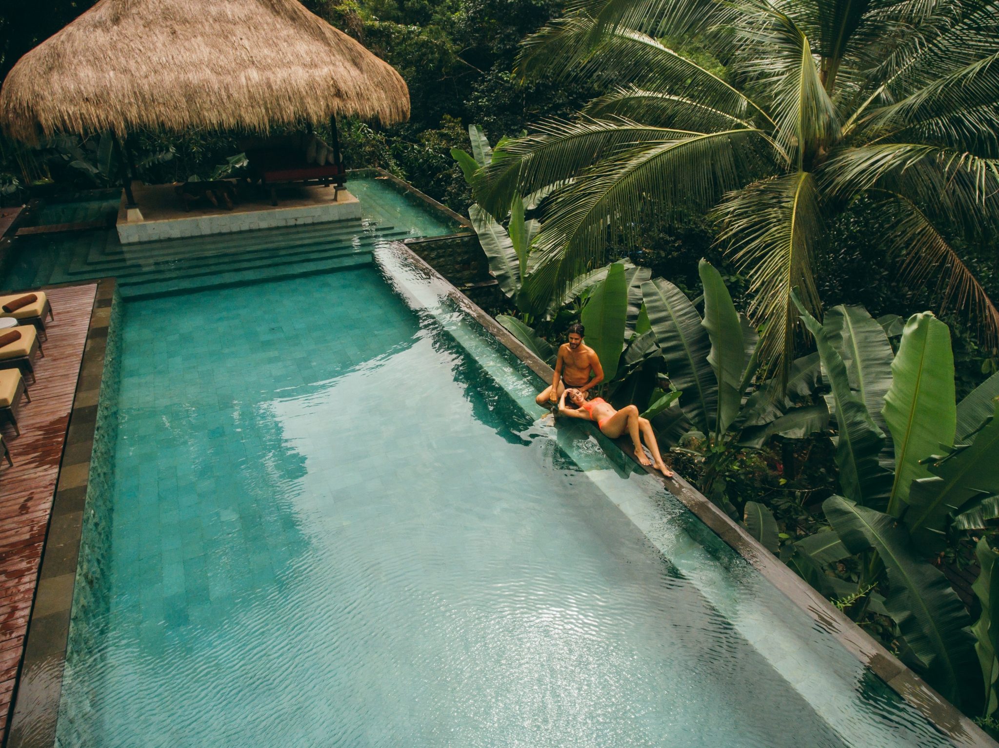 Aerial,Shot,Of,Man,And,Woman,Relaxing,At,The,Poolside.